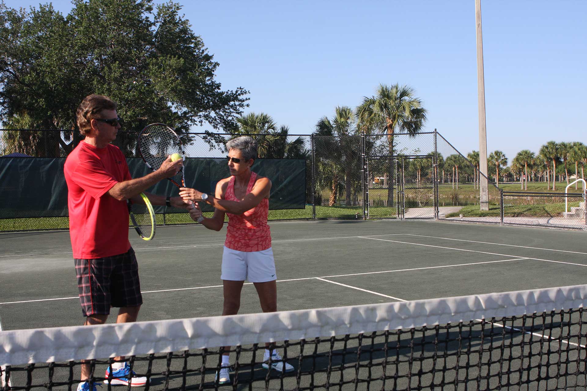 Tennis Instructor with Tennis Player Student on Court