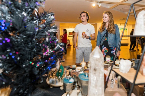 Coral Springs Museum of Art Pine and Palm Holiday Market - Couple looking at merchandise on sale.